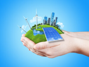 Hands holding clear green meadow with sun battery block, wind mill turbines and city skyscrapers. Concept for ecology, growing business, freshness, freedom and other lifestyle issues. Green fields collection.
