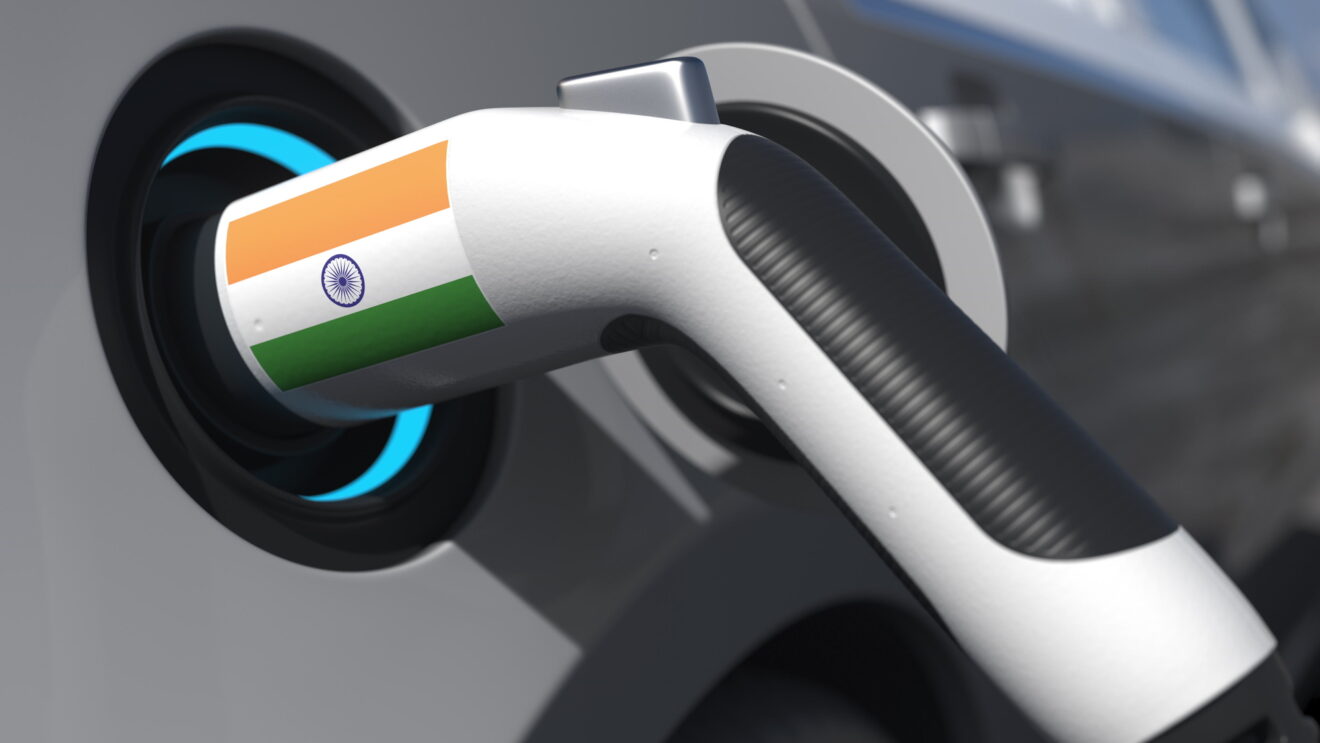 Charging plug in an electric car with the flag of India. Conceptual 3d