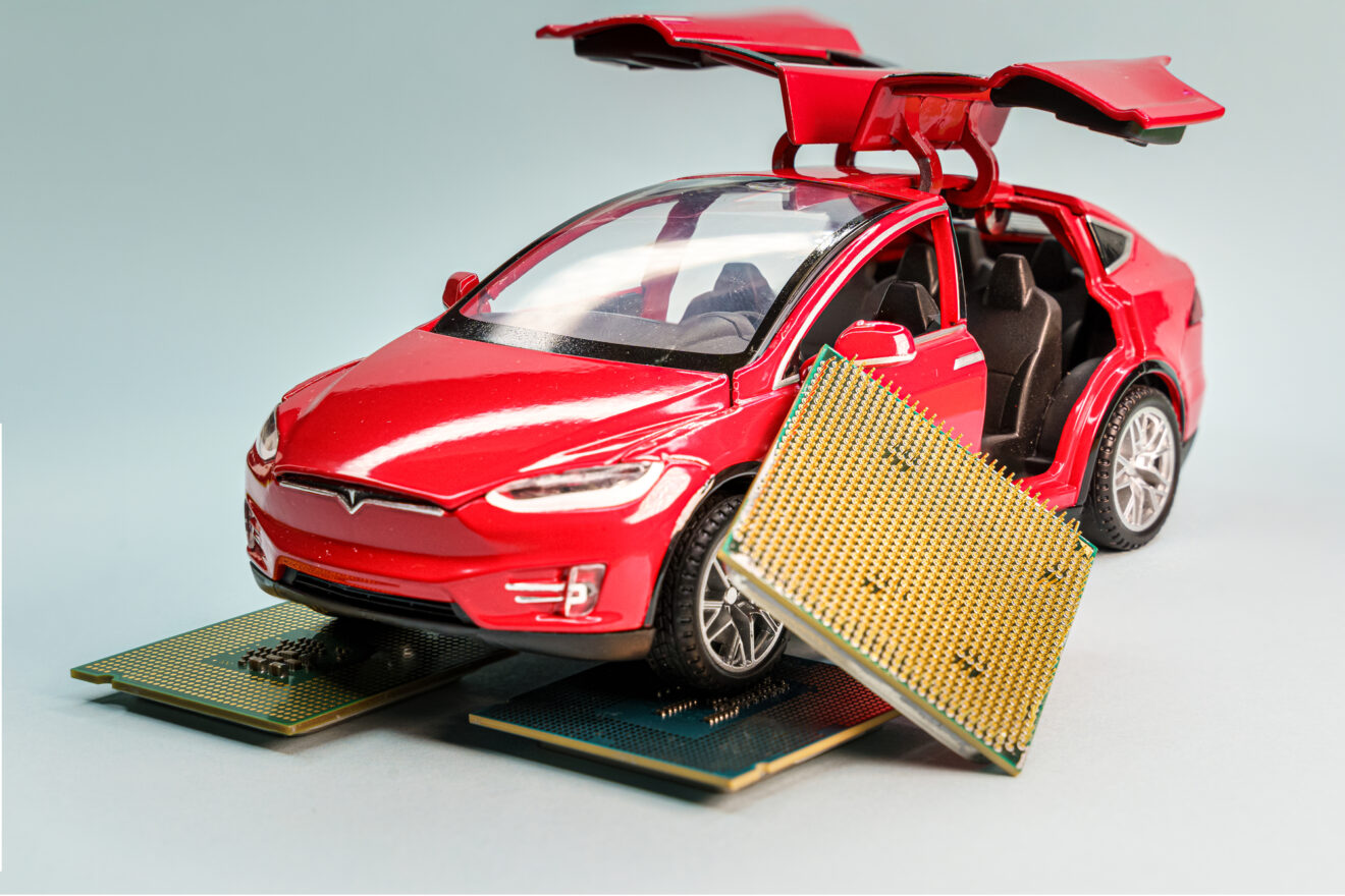 Red Tesla Model X toy car with open falcon wings doors with microchips on the side, symbolizing the Global chip shortage