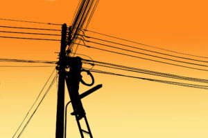 Silhouette of electric engineer on power pole