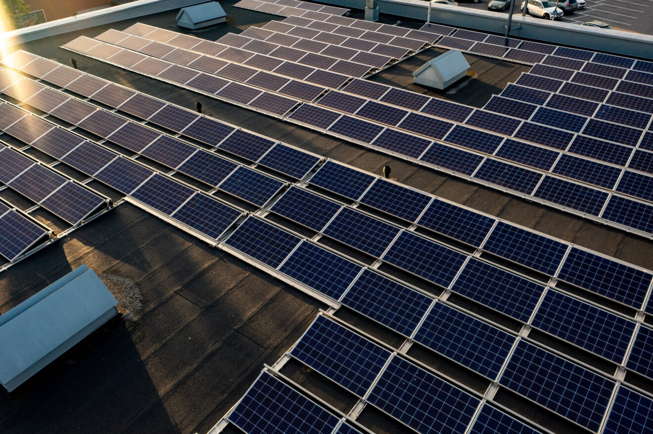 Aerial drone view of solar cells on top of a building