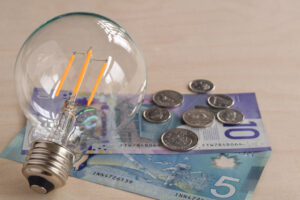 LED light bulb with canadian dollars paper money and coins, energy saving concept